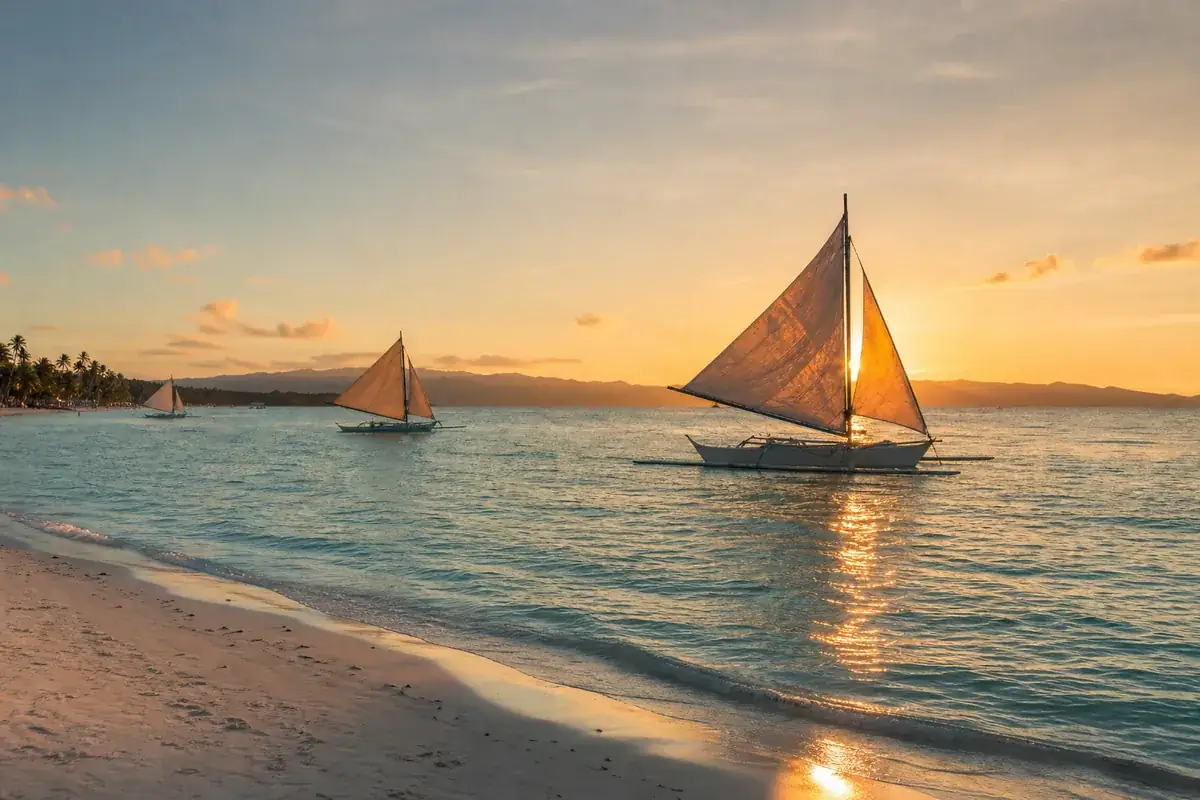 view of paraw sails at sunset along White Beach, Boracay
